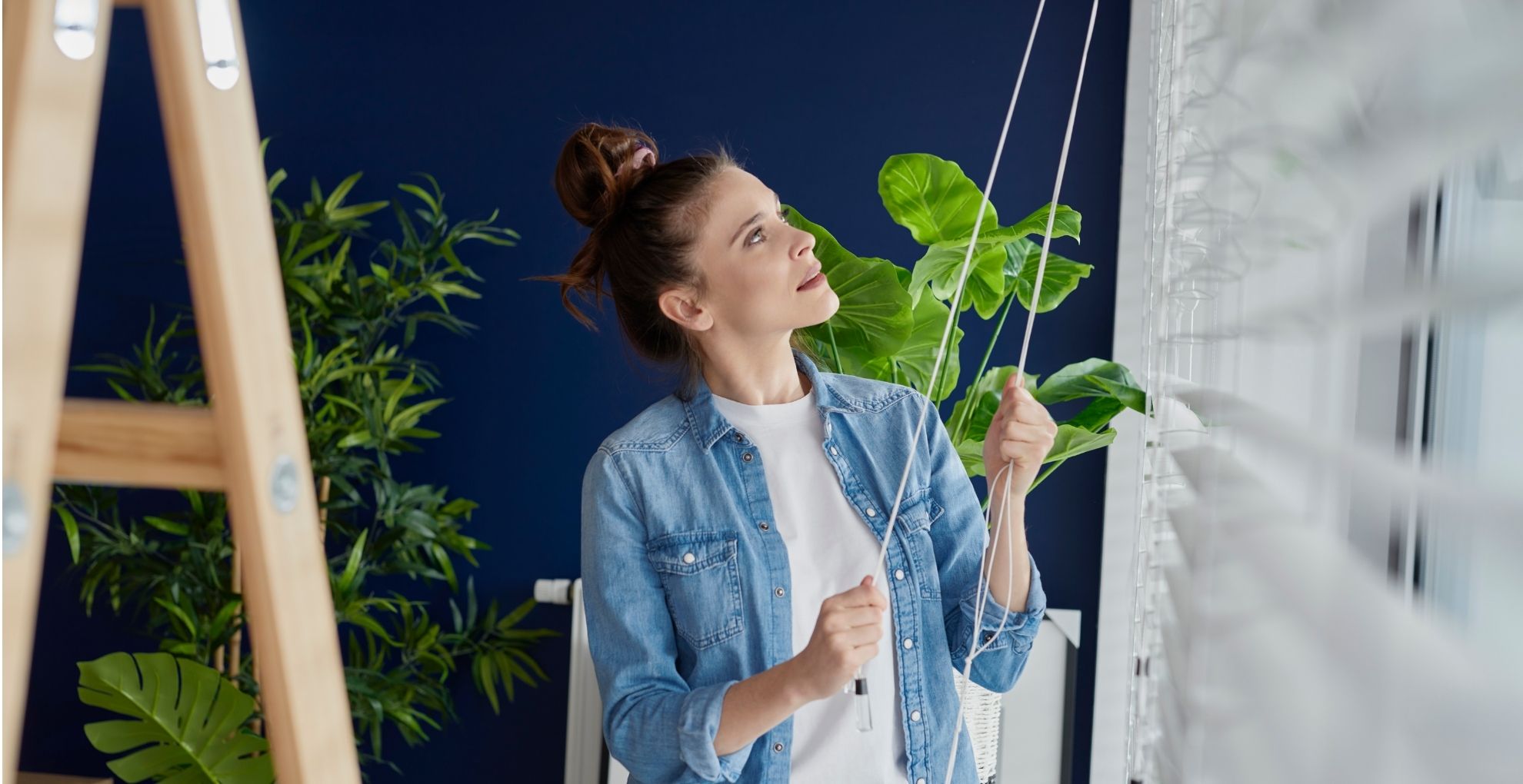 Vrouw bij raam met touwtjes in handen van shutters