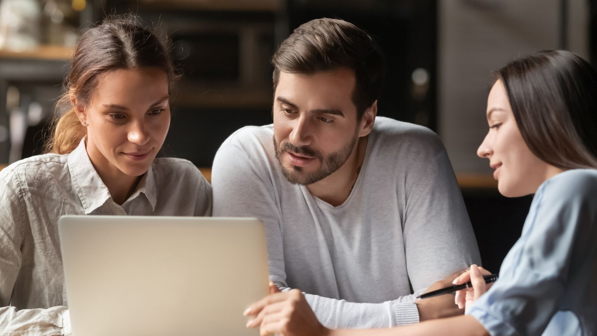 Twee vrouwen en man in gesprek met scherm