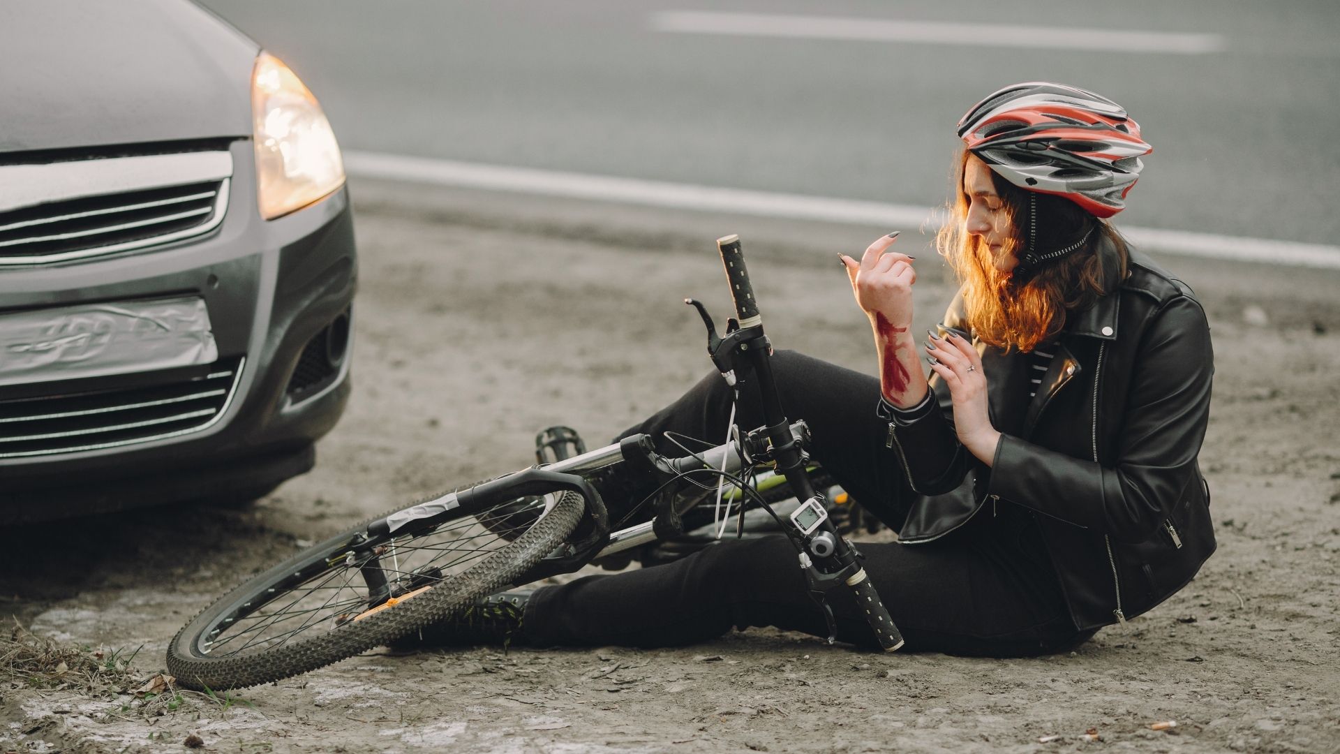 Vrouw gevallen met fiets/aangereden door auto met bloed op arm