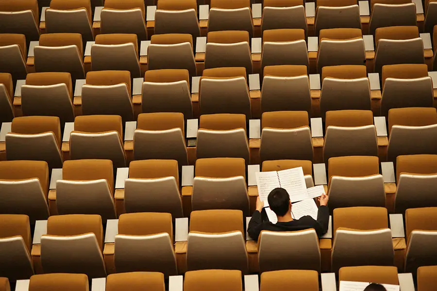 Person reading in a stadium
