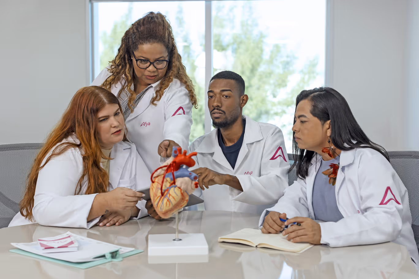 Três alunos de Medicina estudando com a professora.