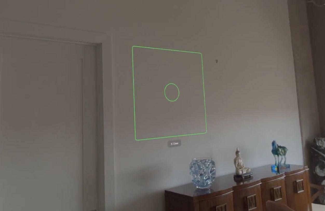 A green outlined rectangle on a bare wall showing where ARKit has detected a vertical surface, above a wooden sideboard.