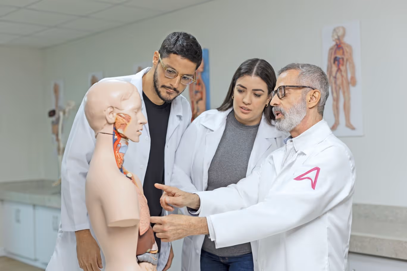 Dois alunos recebendo instruções do professor no laboratório