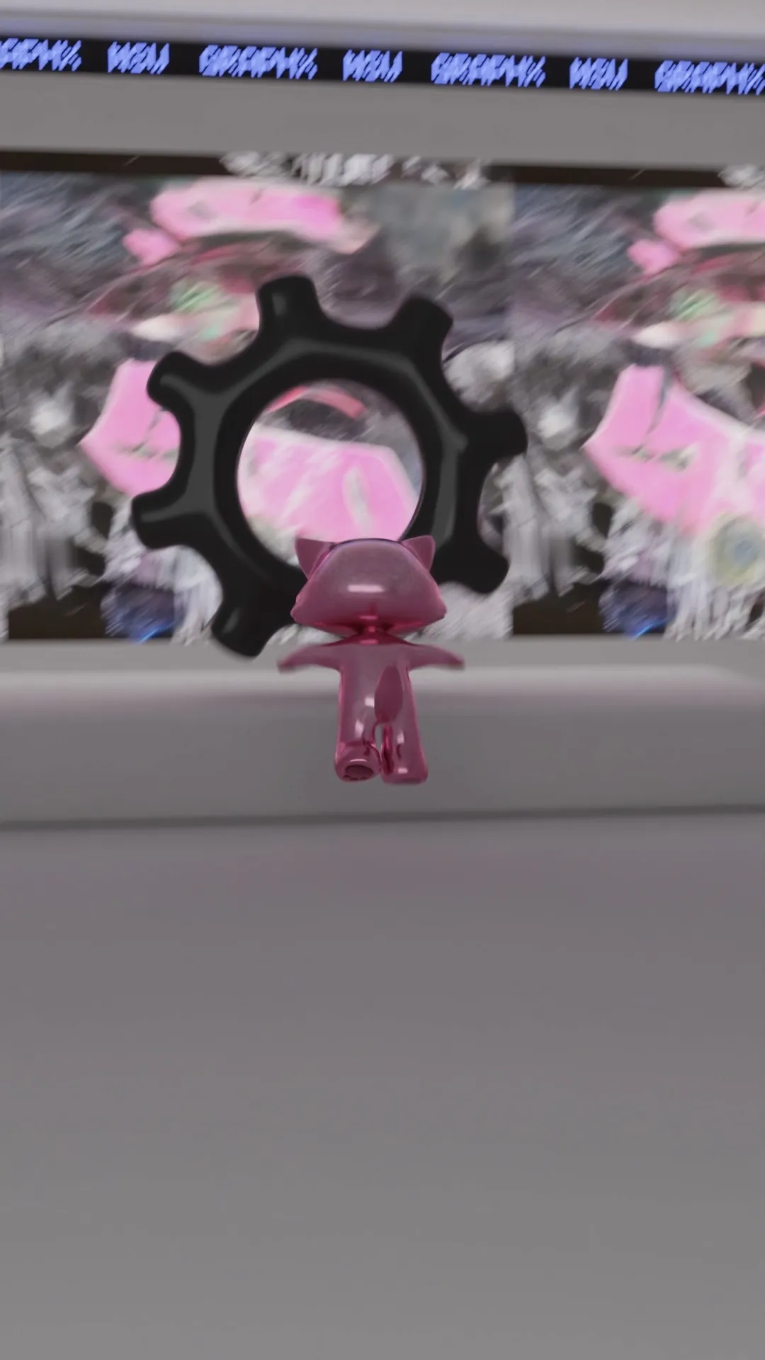 Rear view of a small transparent pink cat figurine facing a large black gear symbol on a screen with blurred pink and grey abstract background.