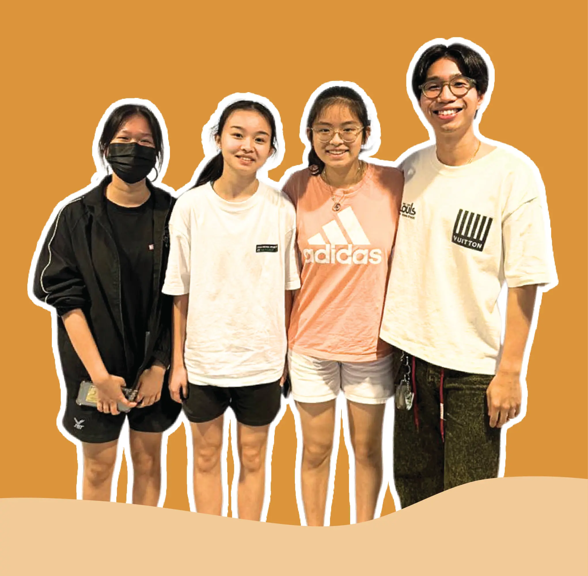 A teacher and his three students stand side by side, smiling at the camera against a solid orange background.