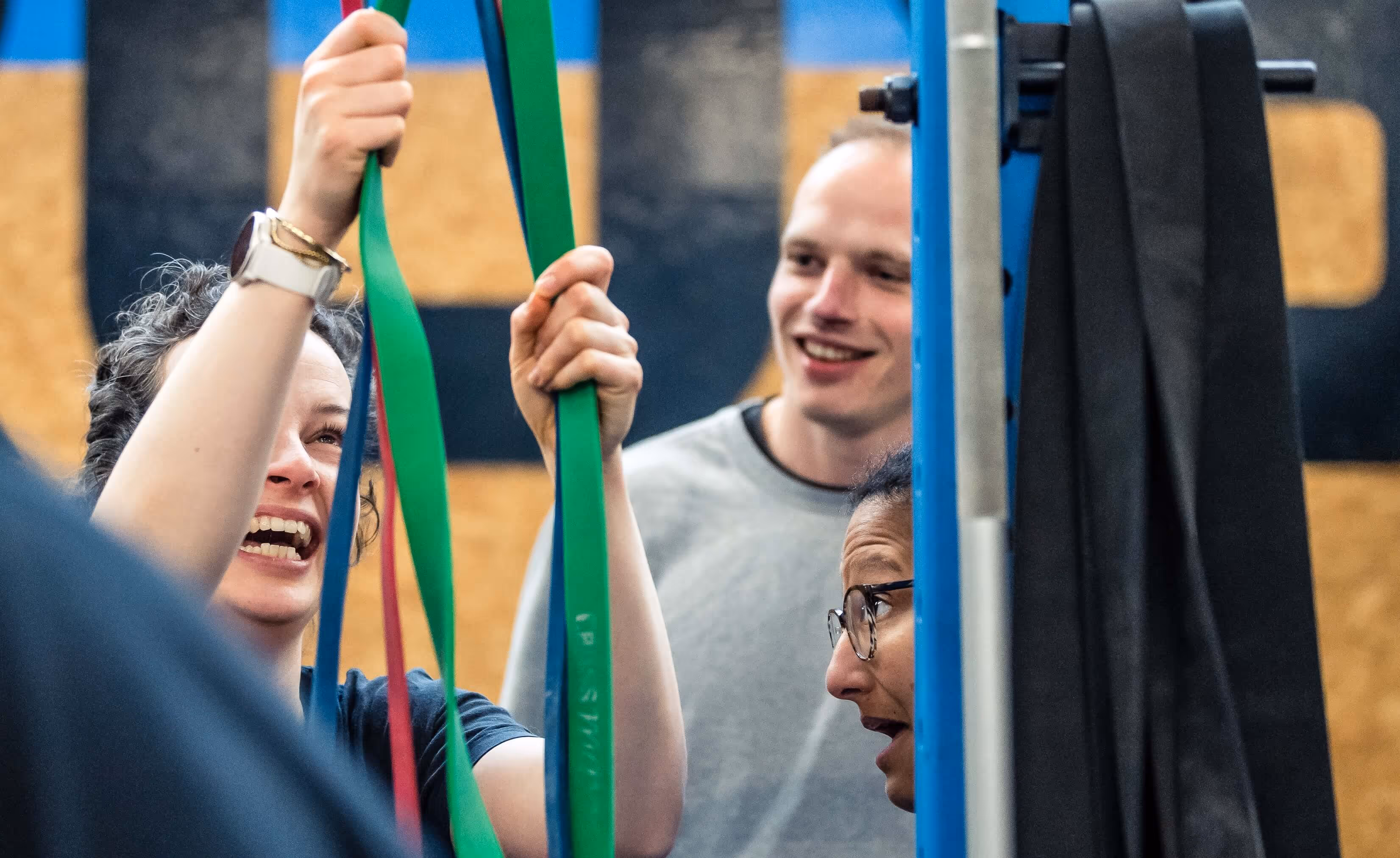 A young mother setting realistic goals in doing pull-ups whilst being supported by her community