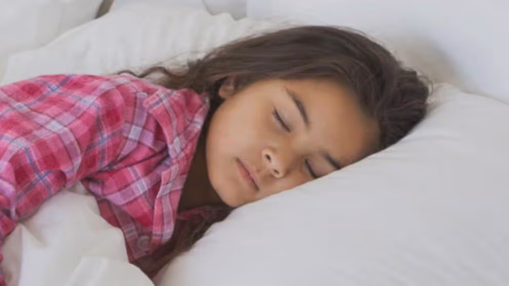 A photo of a sleeping girl wearing a pink shirt