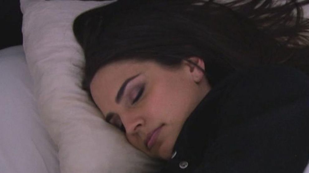 A photo of a sleeping dark-haired woman wearing a black shirt