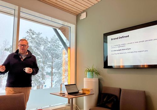 Speaker delivering brand strategy and upselling mastery workshop focused on customer engagement and loyalty.