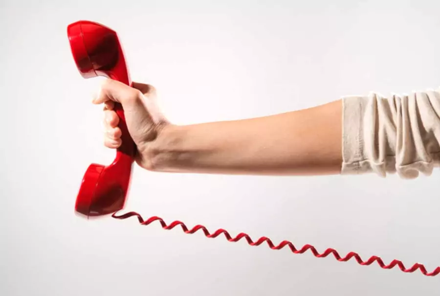 une main qui tient un téléphone rouge