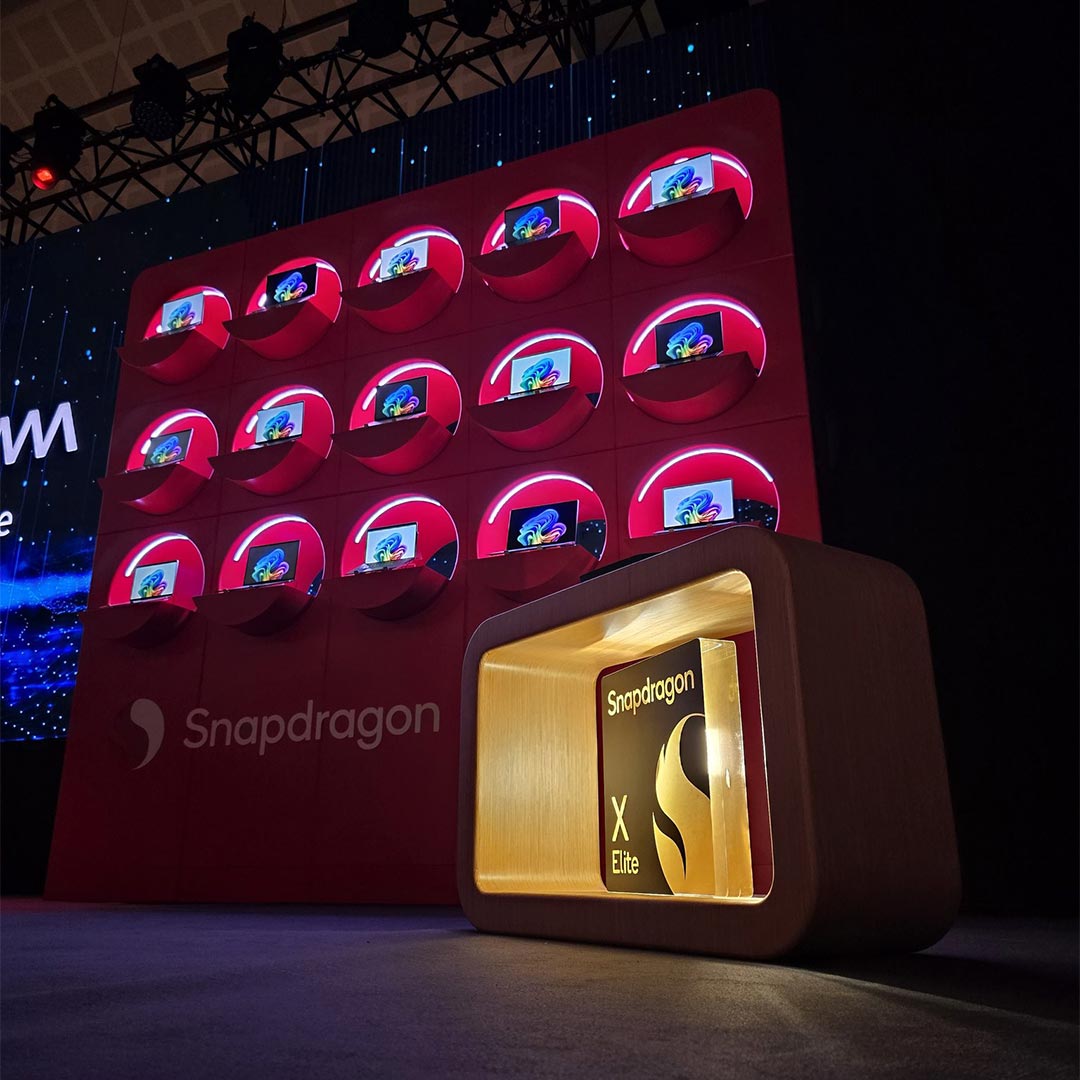A red Snapdragon X Series Copilot+PC 3D laptop display is shown on stage at Computex featuring a glowing X Elite chip.