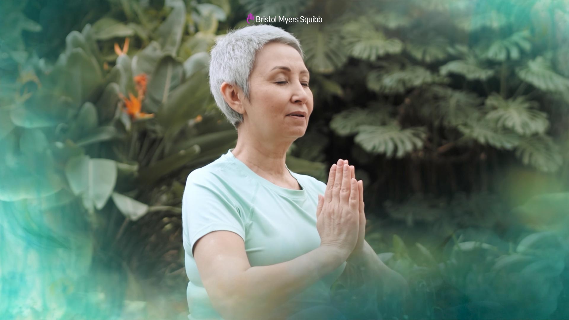 A woman with short gray hair does yoga outdoors with her eyes closed. Text reads "Bristol Myers Squibb."