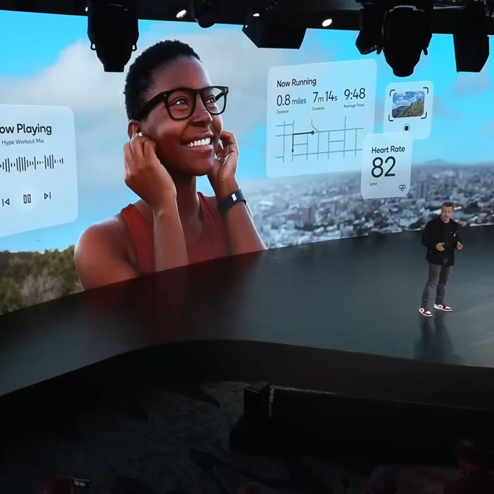 A man is onstage at Qualcomm's Snapdragon Summit in Maui, Hawaii. The screen behind him shows a runner tracking metrics.
