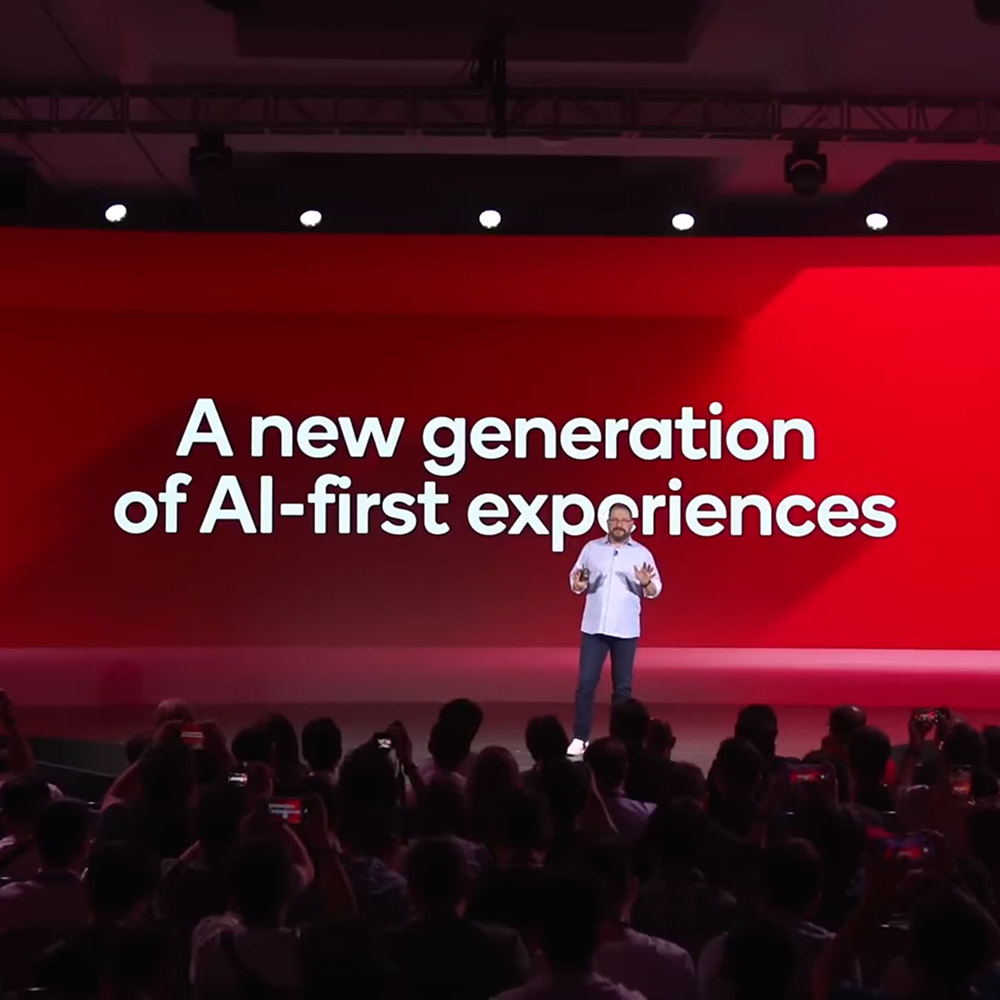 Cristiano Amon stands onstage at Snapdragon Summit in front of text that reads "A new generation of AI-first experiences."