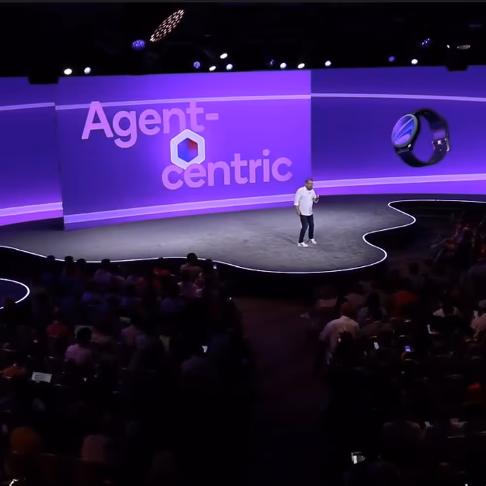 The big screen at Snapdragon Summit shows the headline "Agent-centric" surrounded by floating smart devices.