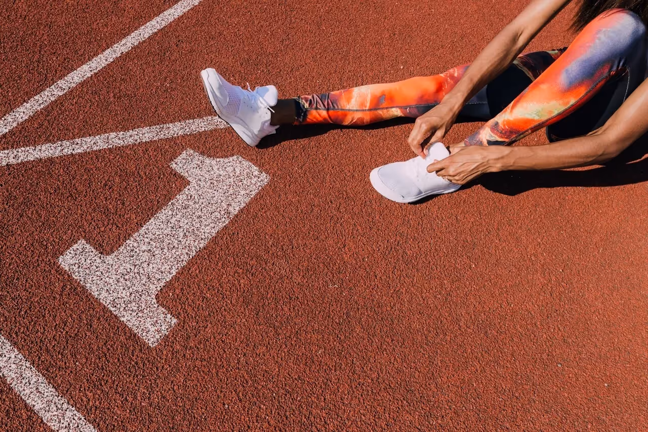 Woman lacing up shoes on a track