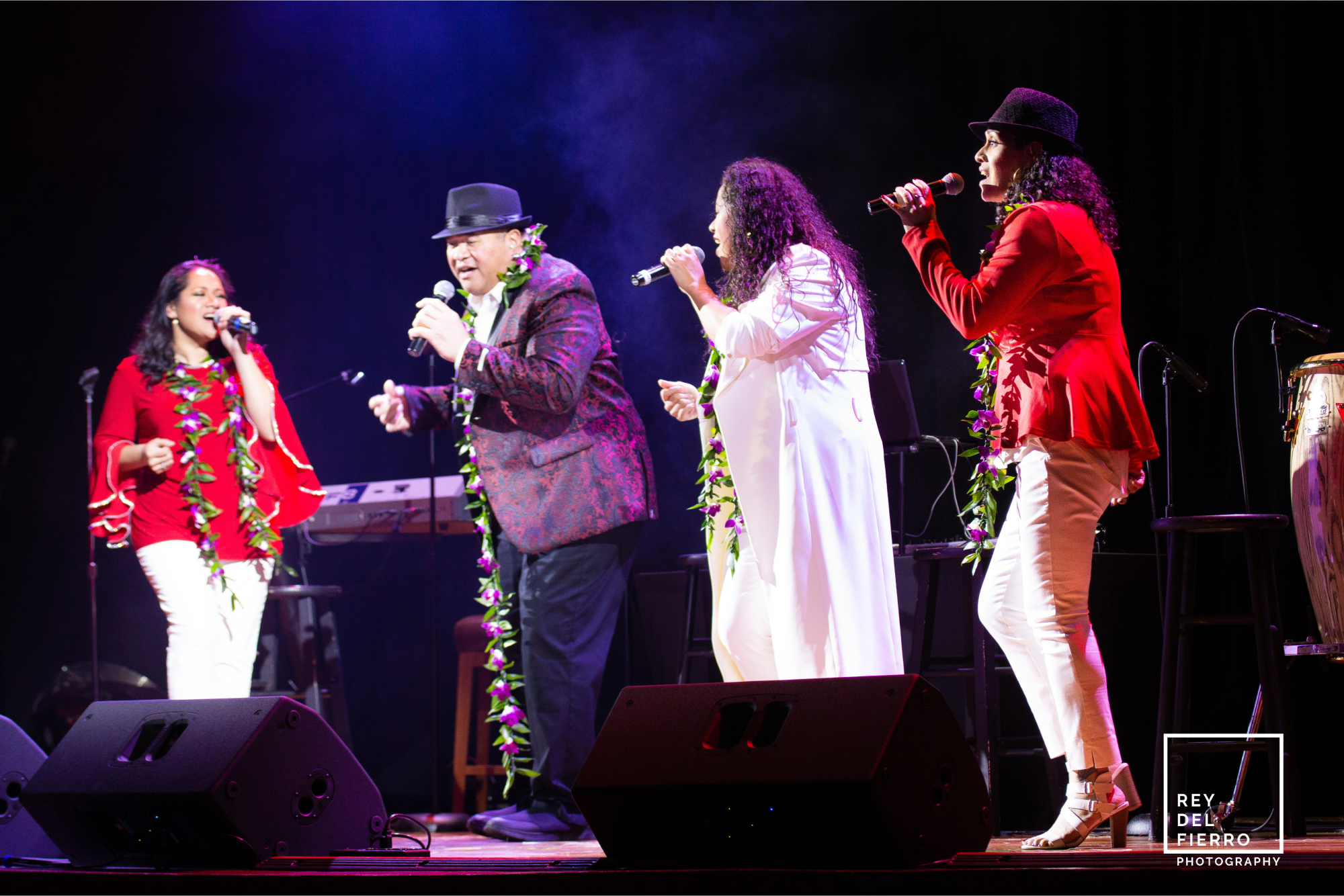 Four singers singing together on stage
