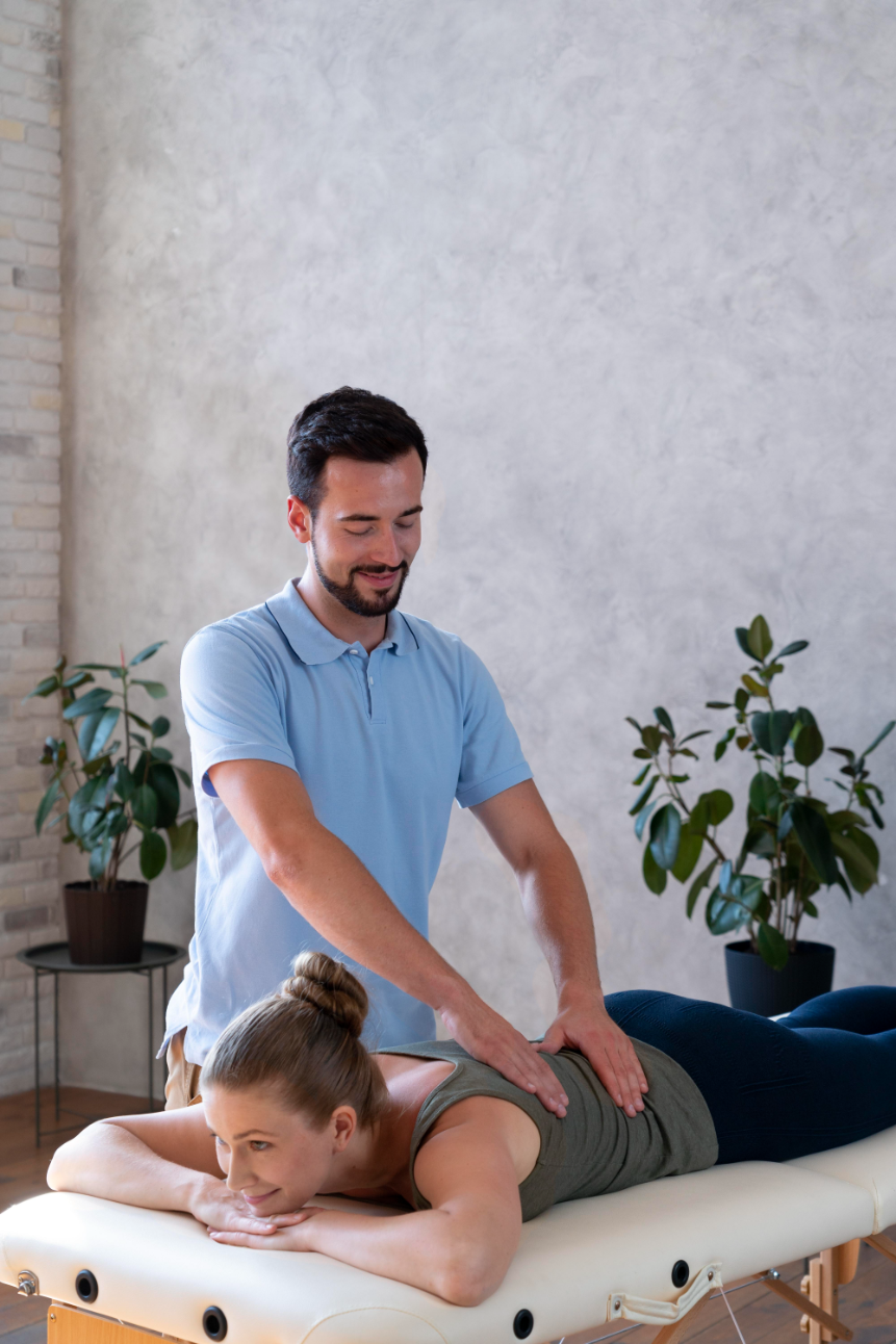 A chiropractor in a blue polo adjusting a woman's back.