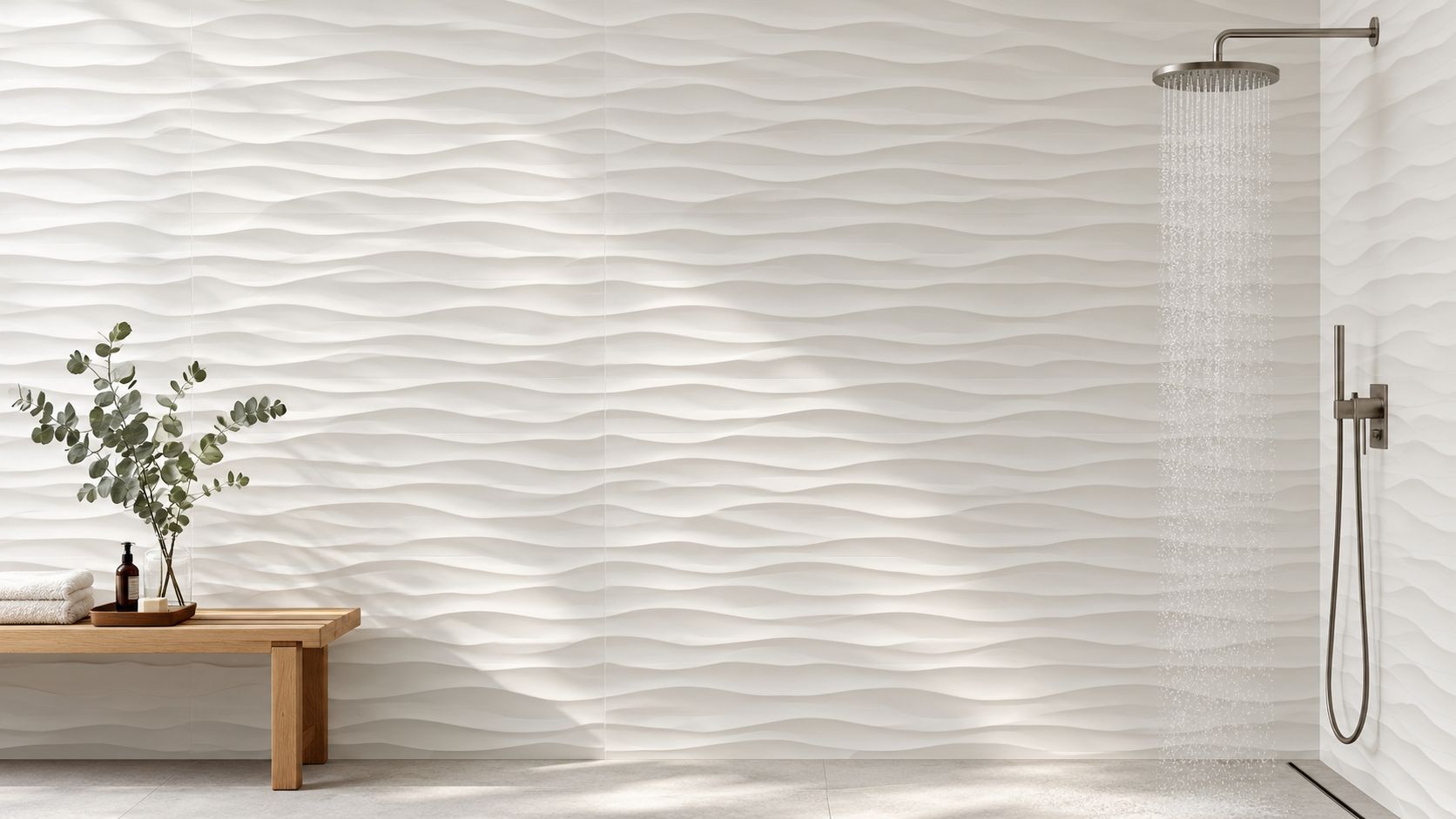 A modern bathroom with white wave-textured wall tiles, a wooden bench, and a brushed nickel rainfall shower.