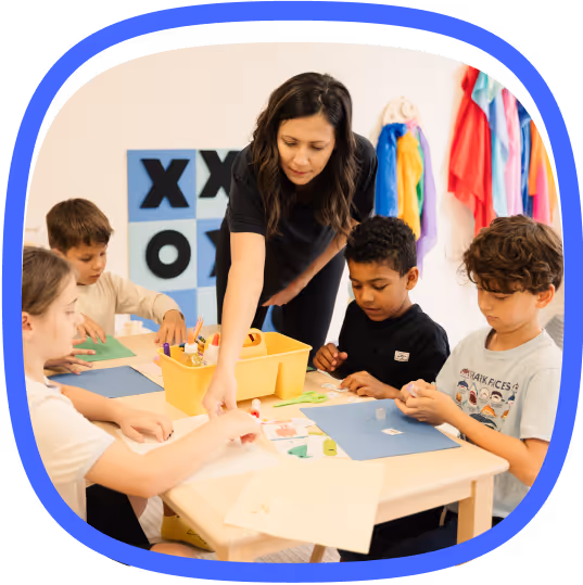 Therapist directing group of kids at a table