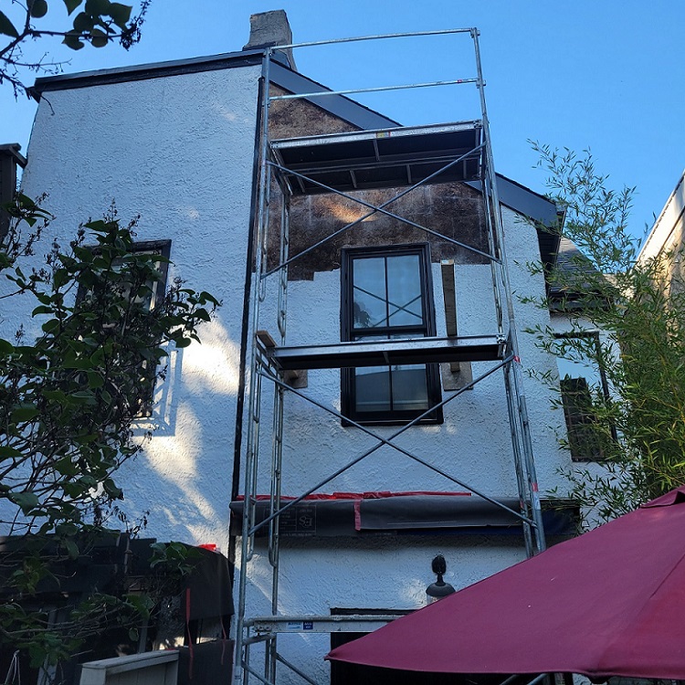 Set up scaffold and removed the bulged stucco section of the house exterior