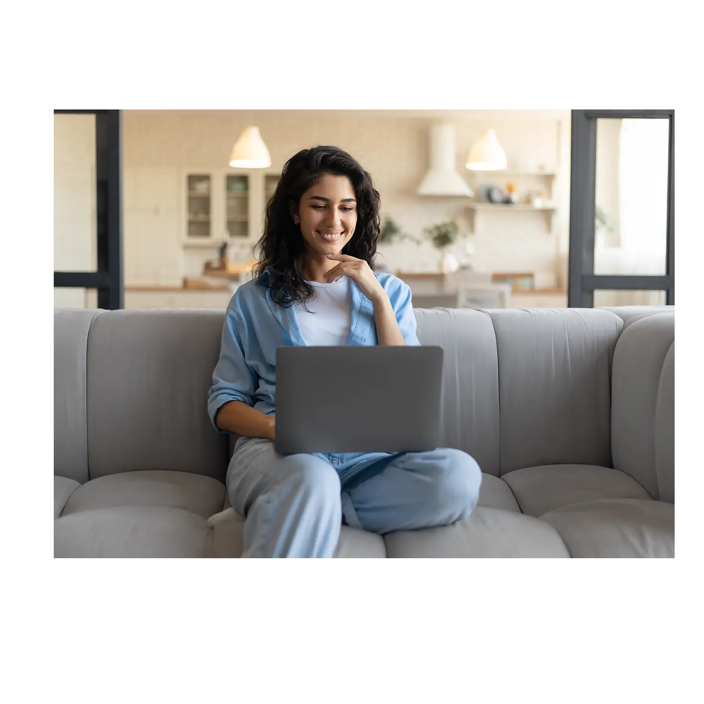 Woman on sofa at laptop smiling