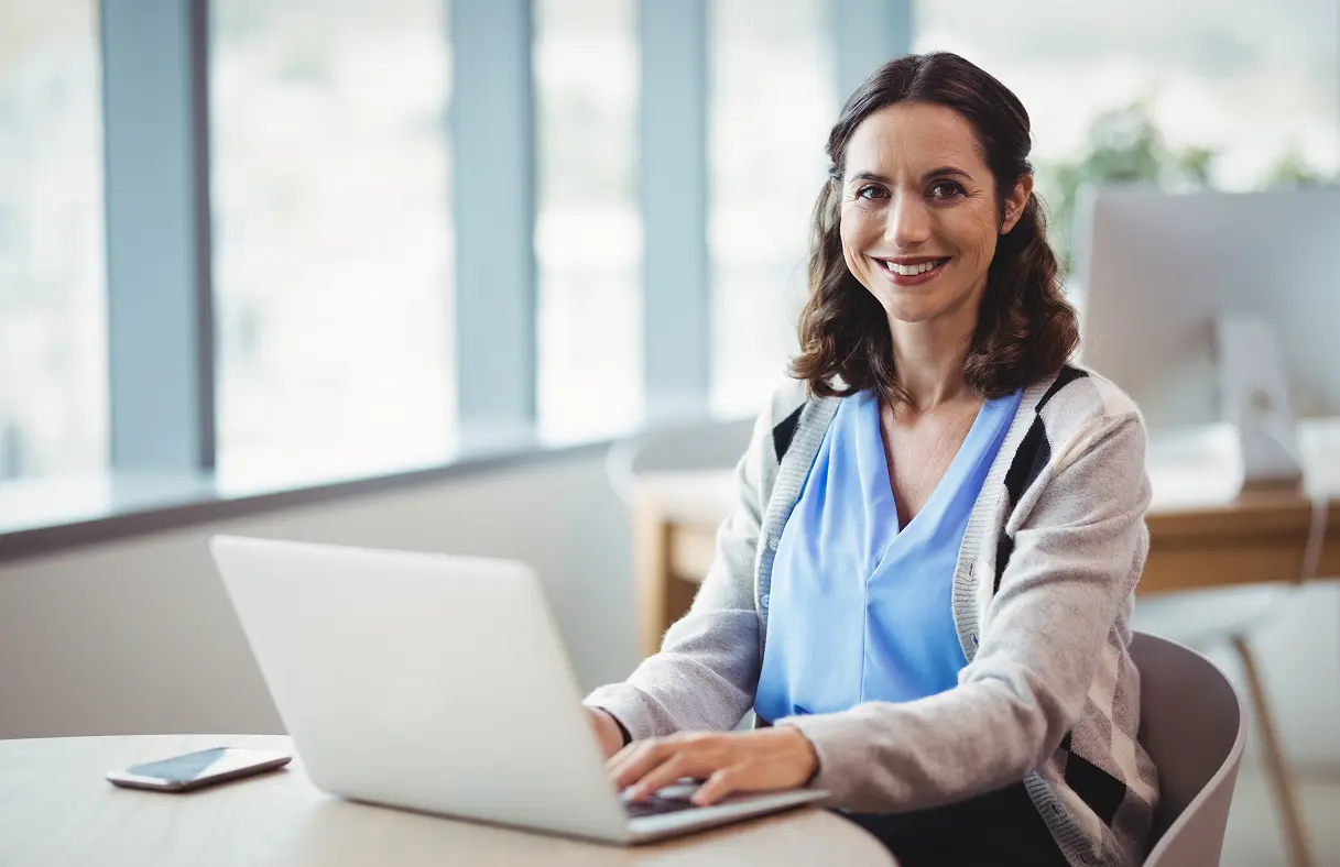 Doctor on laptop looking at the camera