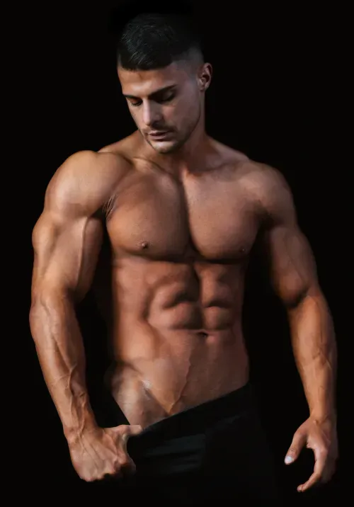 A muscular and fit man posing against a dark background.