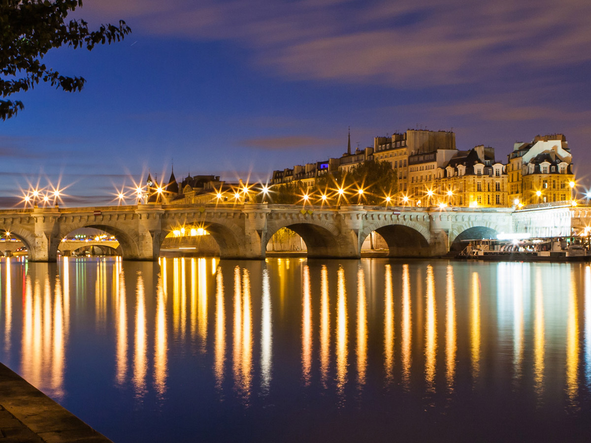 Paris illuminé et la Seine la nuit, accessible en 12 minutes depuis la gare de Bois-Colombes — conciergerie Airbnb proche Paris