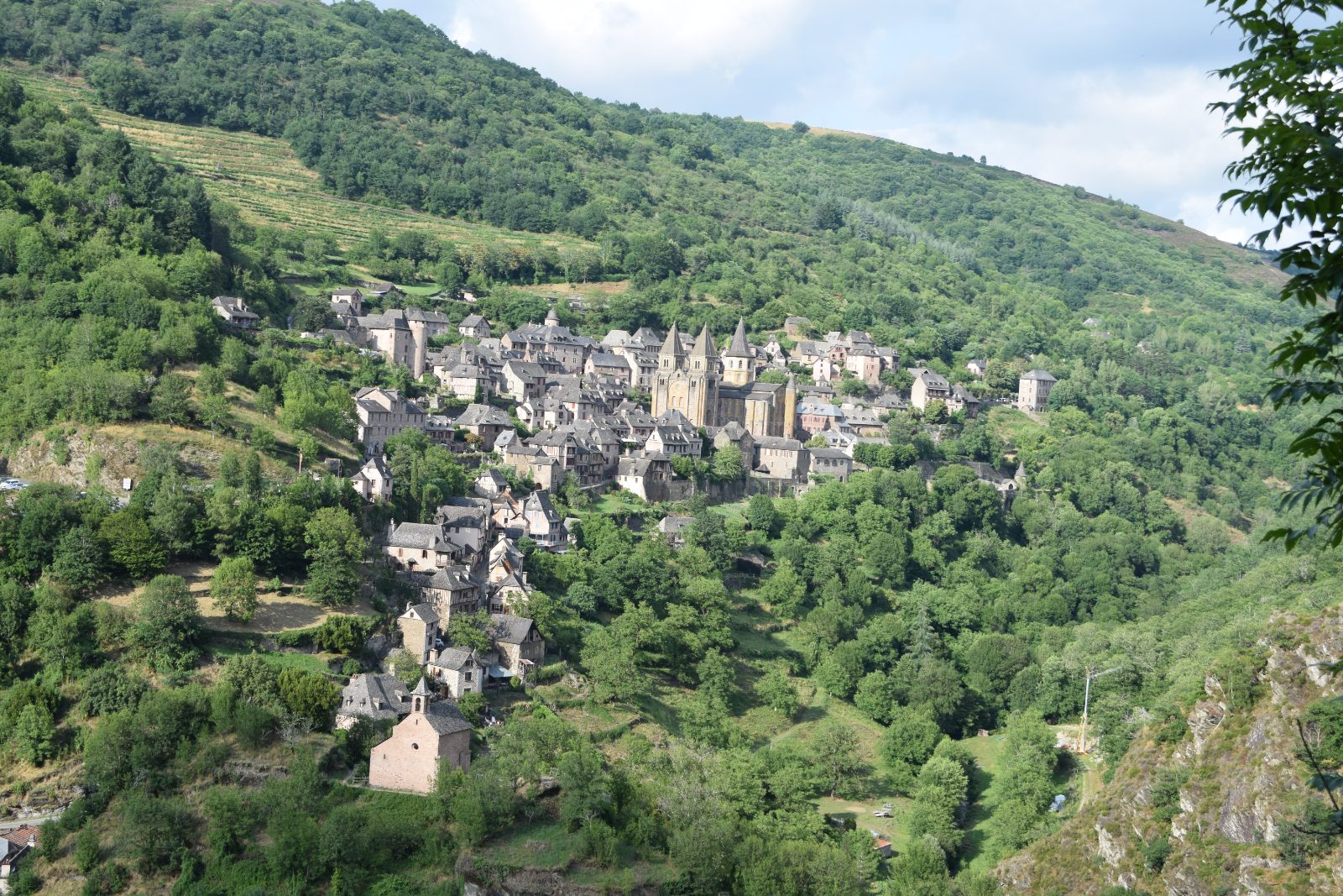 Village médiéval de Conques niché dans la verdure de l'Aveyron — location saisonnière Aveyron