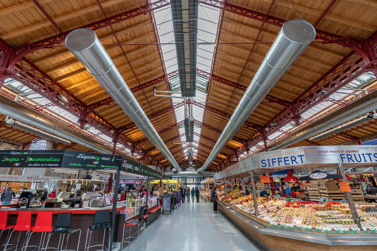 Étals du marché couvert de Colmar sous sa charpente en bois — conciergerie Airbnb Haut-Rhin