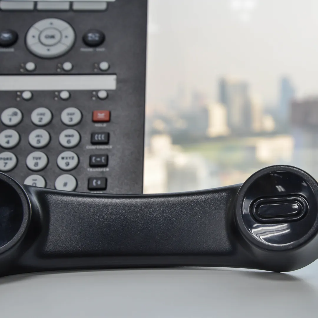 A phone handle off the hook with a phone console