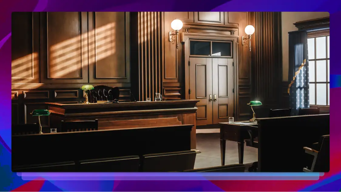 Front of a small courtroom with the judge’s bench, plaintiff and defendant tables, and doorway to the judge’s chambers.
