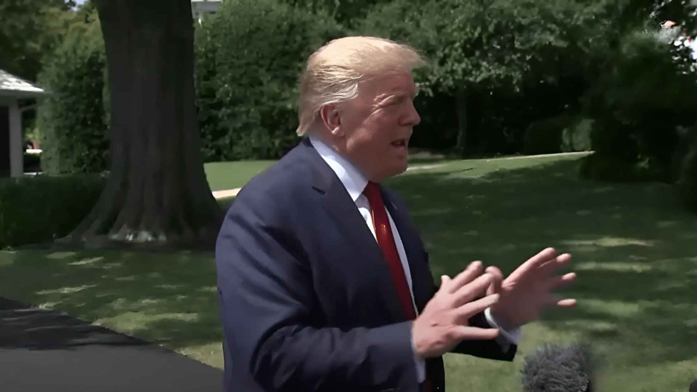 Trump speaks and gestures to press.