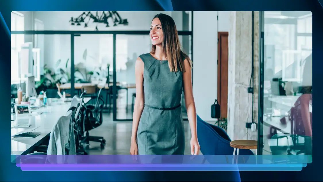A professional woman in a gray dress walking confidently through a modern office