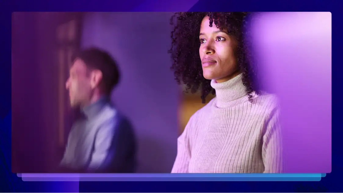 Woman looking ahead thoughtfully with a blurred person in the background
