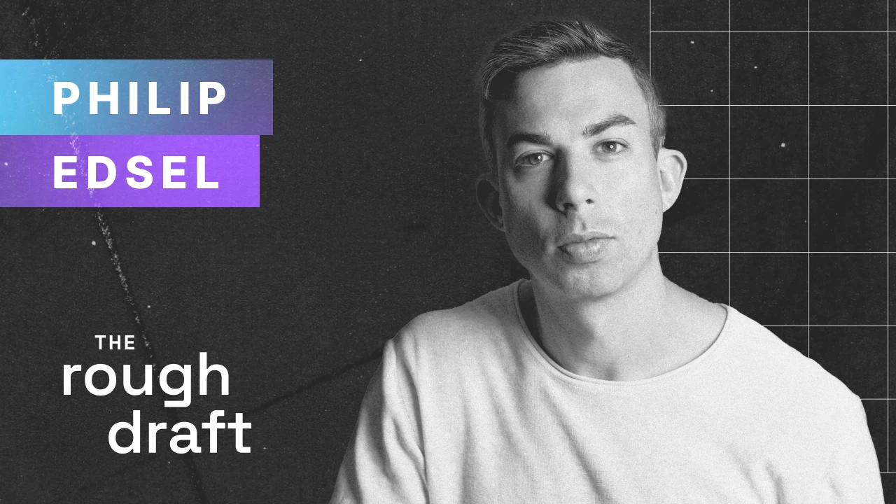 Headshot of a smiling person in blazer against dark studio background, professional portrait