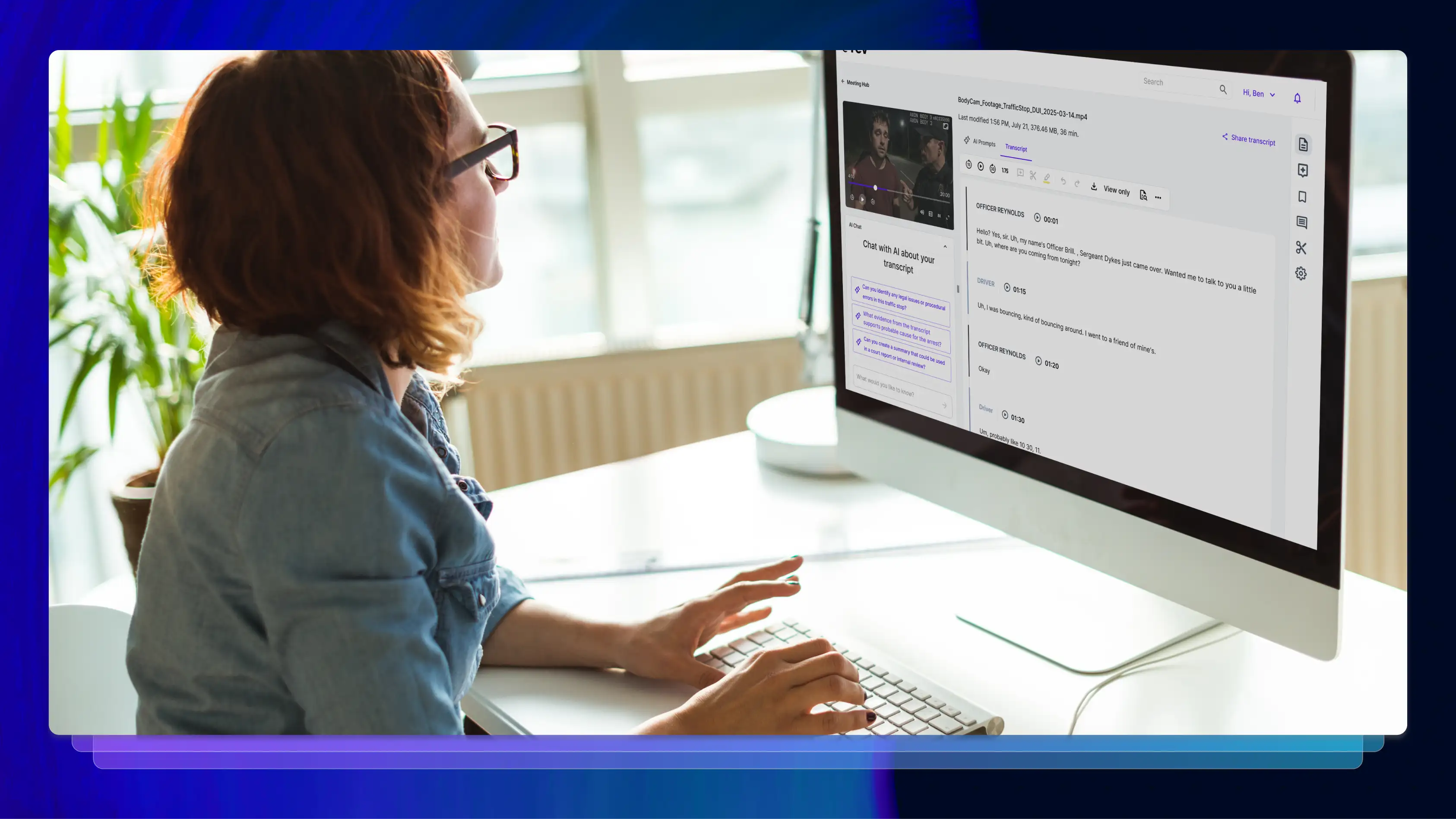 Woman typing while looking at a desktop computer screen in a brightly lit office.