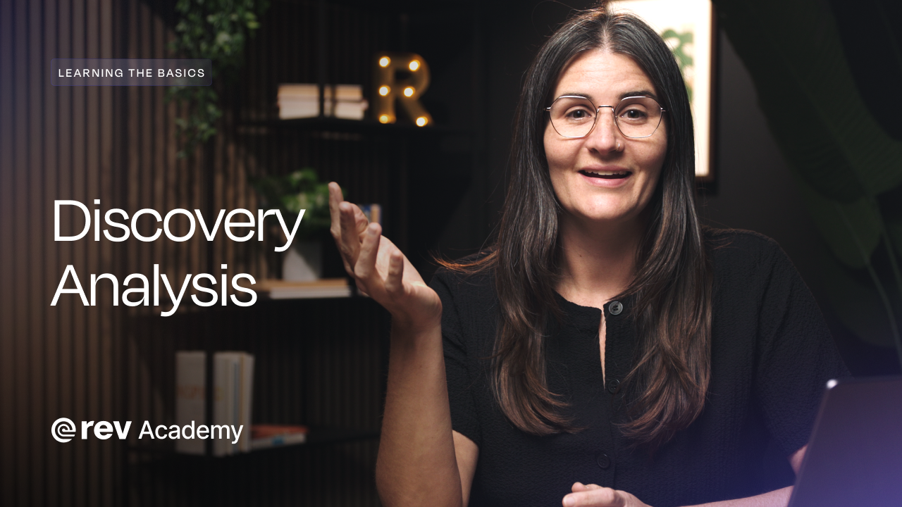 A woman in a black shirt and glasses speaks and gestures to the camera. The words "Learning The Basics," "Discovery Analysis," and "Rev Academy" are on the left hand side.