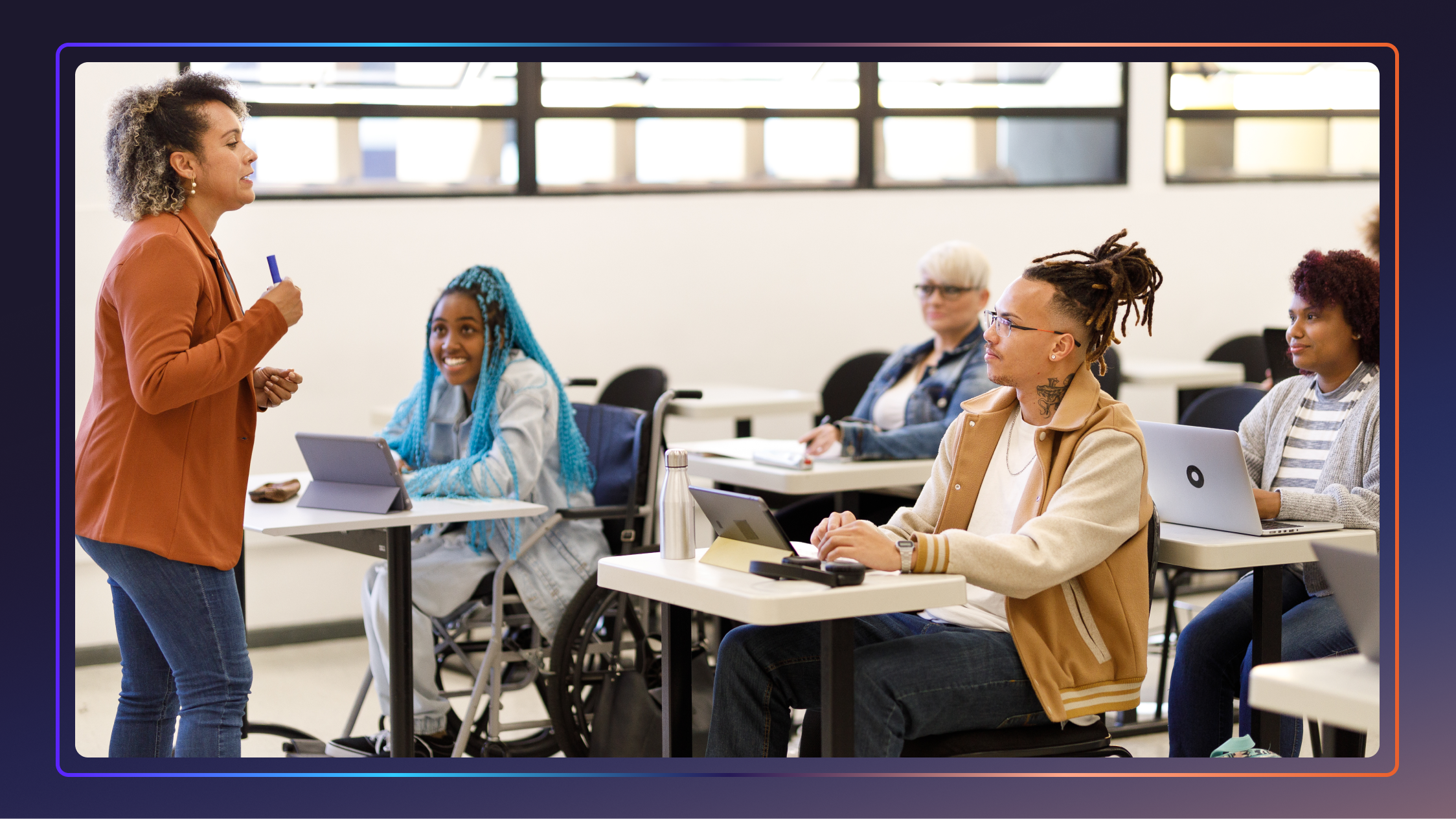 A teacher stands up and gives a lecture to a diverse group of students.