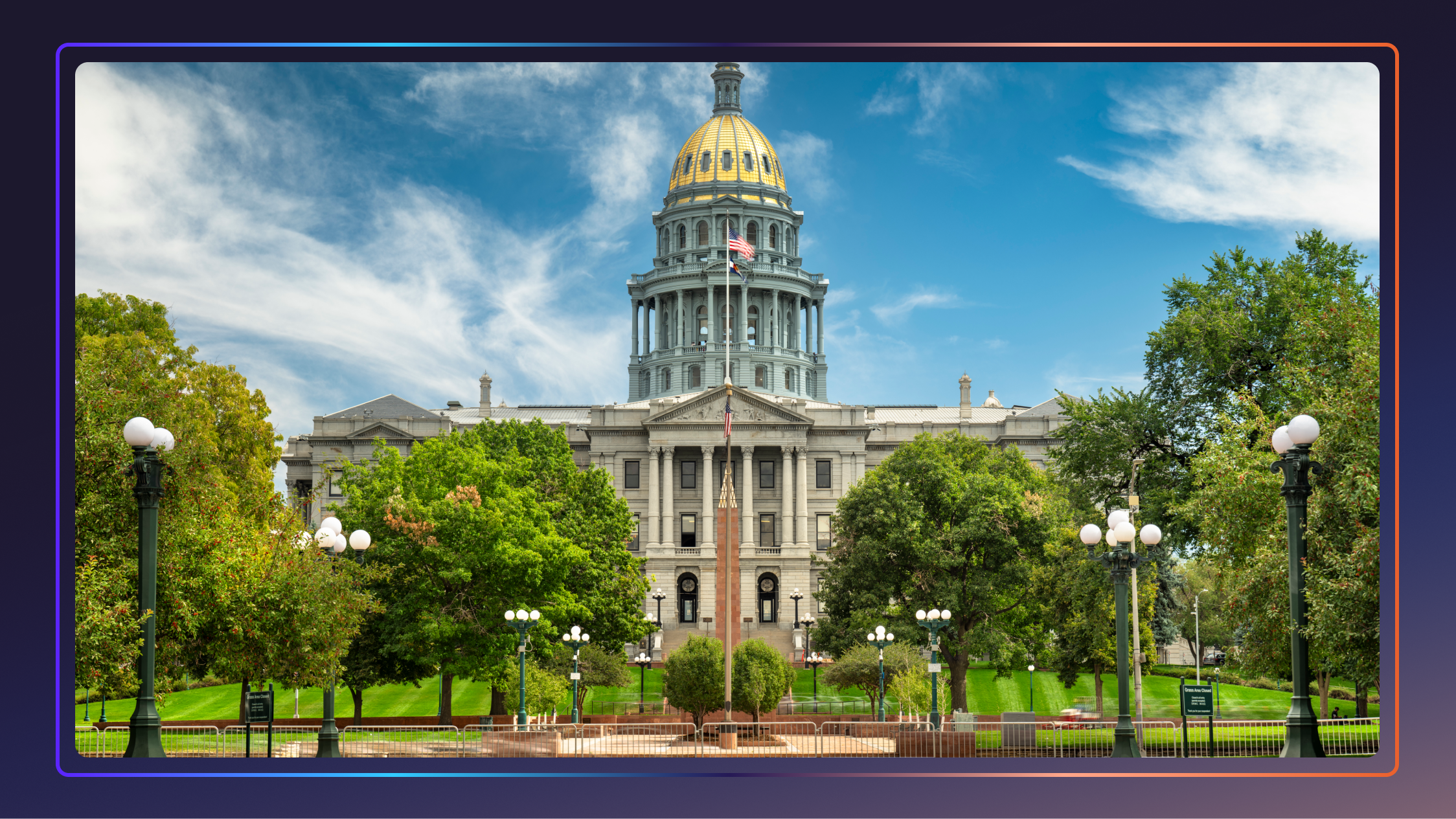 Colorado State Capitol building in Denver surrounded by a blue sky and trees.