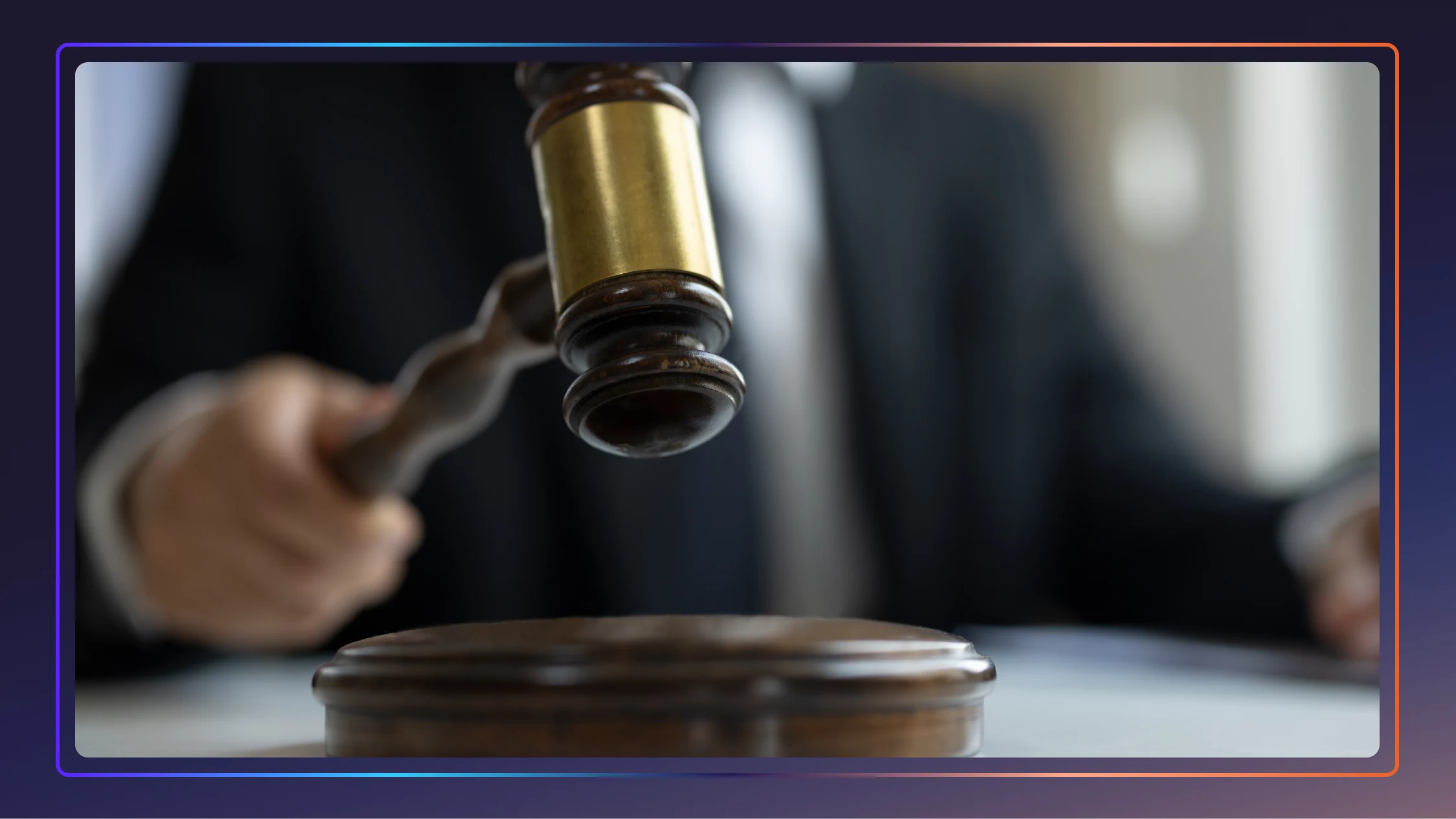 A gavel being hit on a desk, with a man blurred behind it holding the gavel.