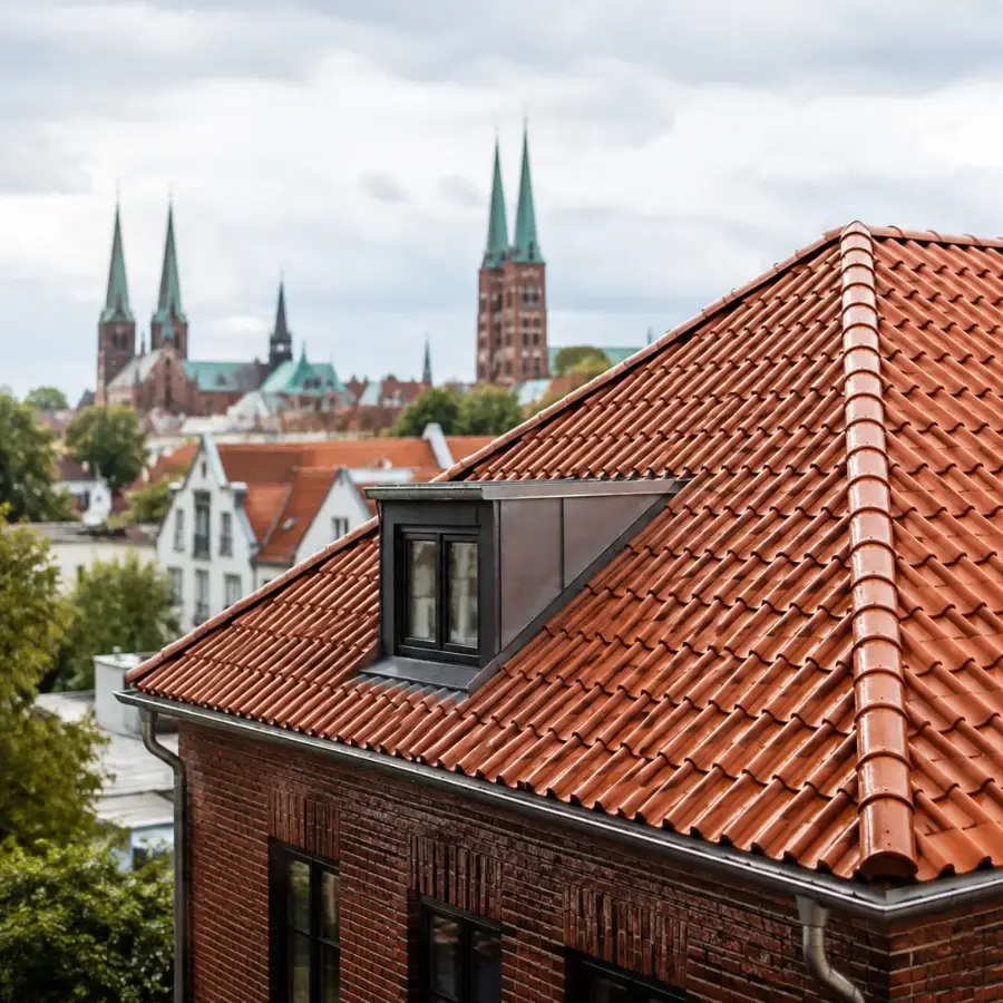 Sauberes rotes Ziegeldach nach der Dachreinigung in Lübeck mit Blick auf die historische Altstadt
