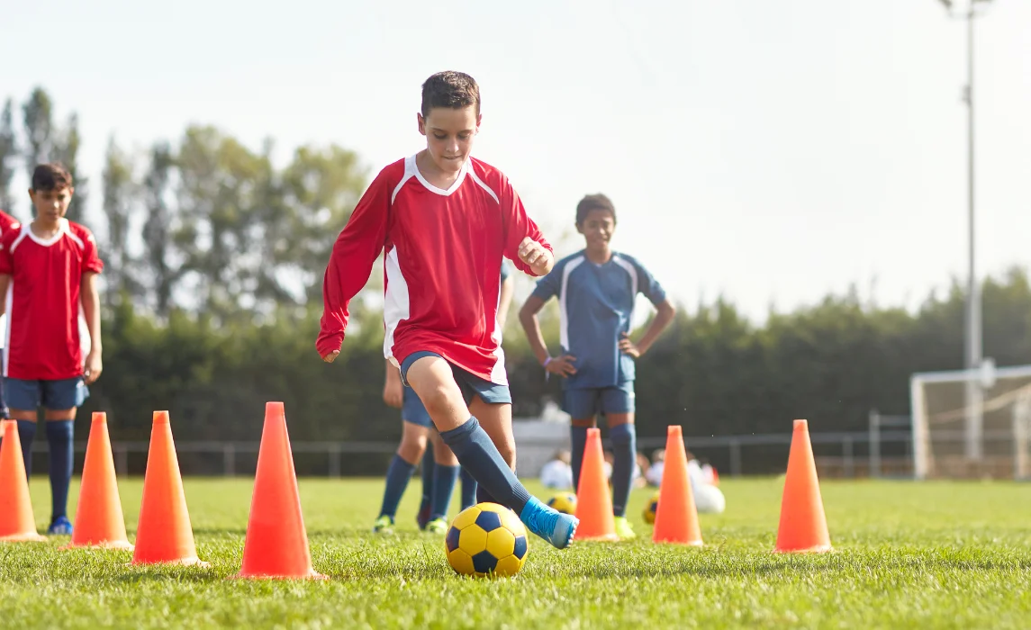 kid playing soccer in the field
