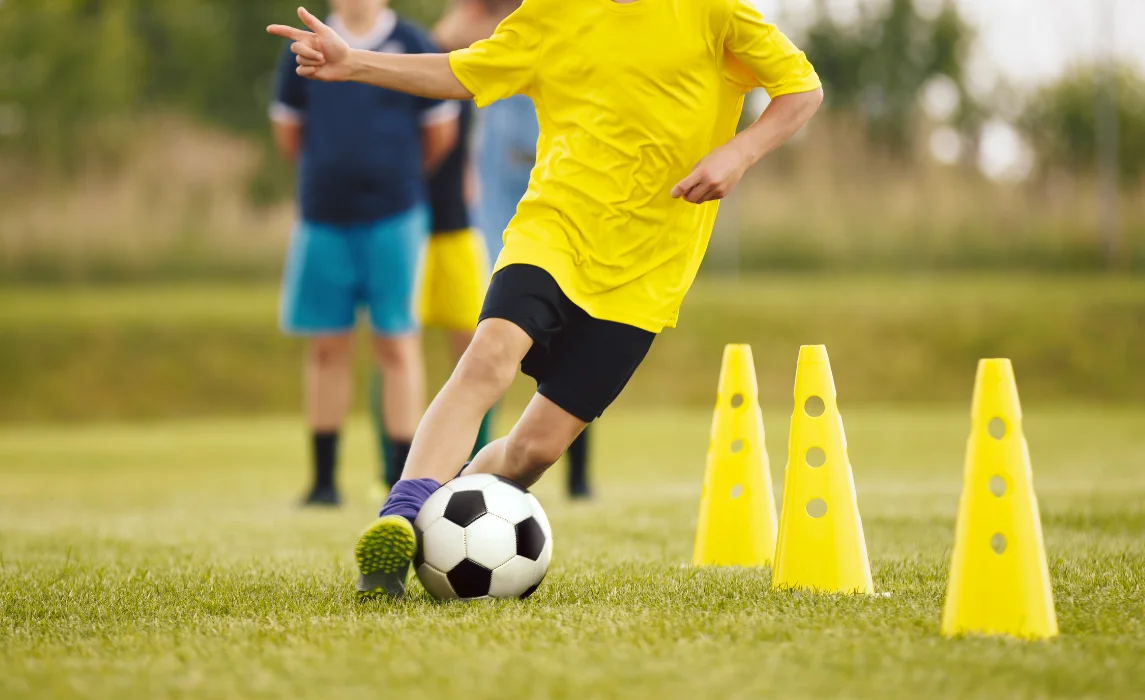 kid in yellow shirt playing soccer