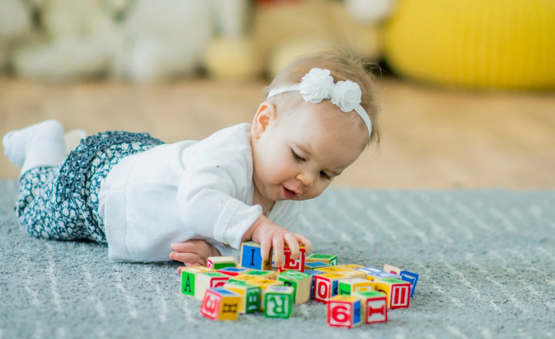 baby playing with letter blocks