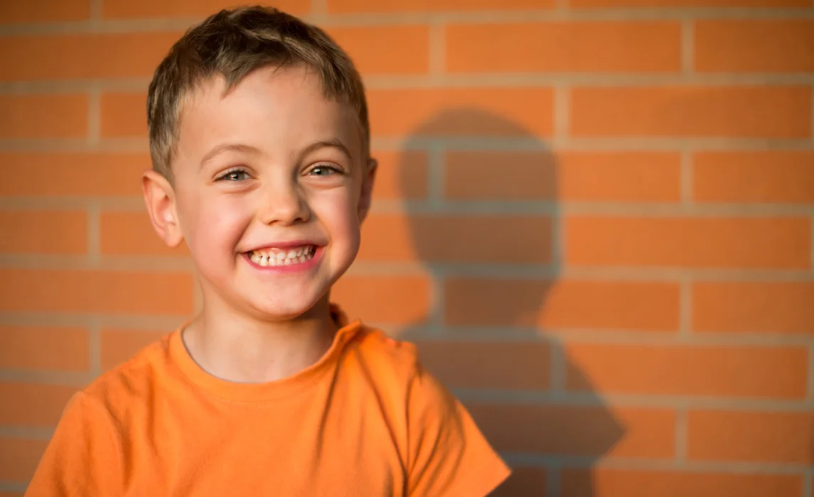 kid with orange brick background