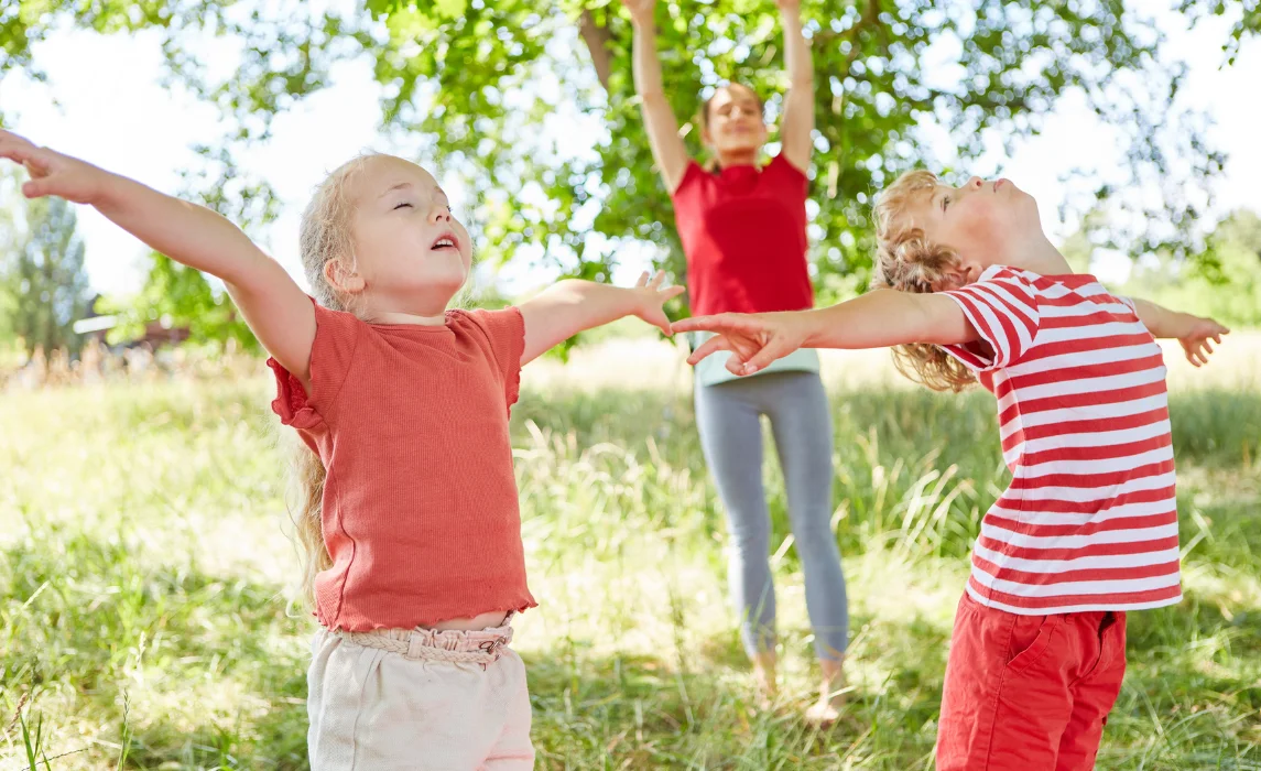 group of kids meditating in the park