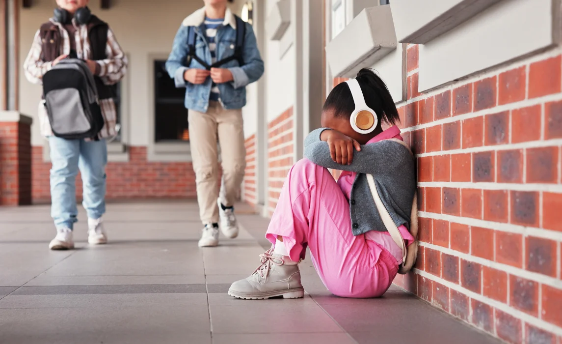 kid alone in the hallway crying with her headphones on