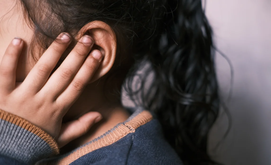 kid covering her ear with her fingers